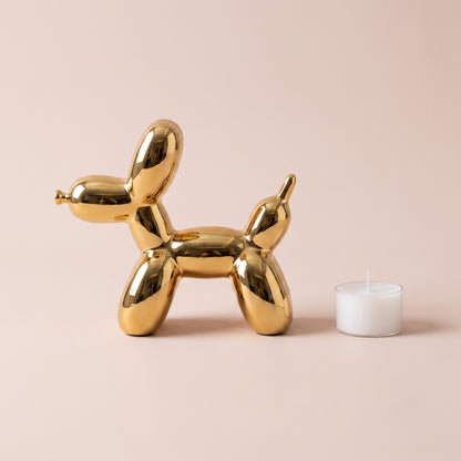Golden Balloon Dog Sculpture side profile shown with a tealight candle for scale