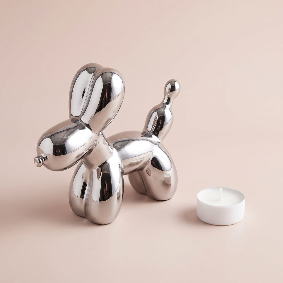 Silver Balloon Dog Sculpture shown with a tealight candle for scale